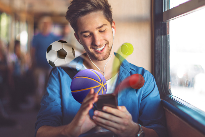 Man looking at phone with sport balls flying out of phone