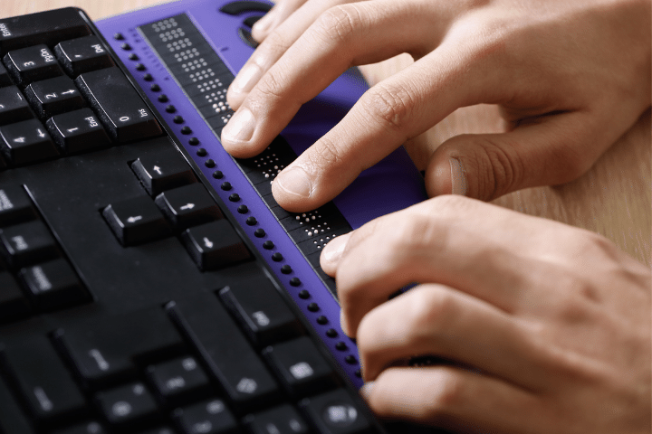 Purple laptop with with braille computer display attachment